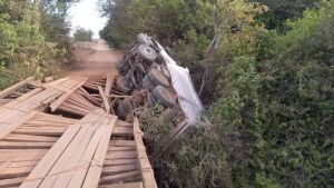 Ponte de madeira cede e caminhão fica pendurado em estrutura 