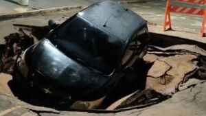 Carro cai em cratera aberta após forte chuva em Coxim 