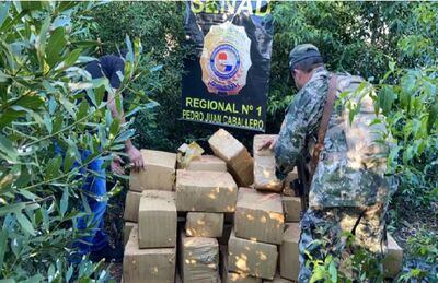 Agentes da Senad empilham fardos de maconha encontrados na fronteira 