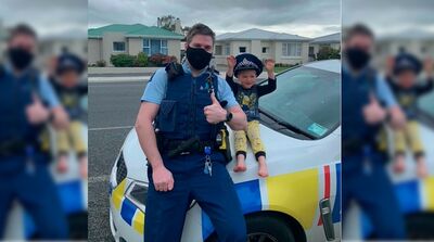 Policial identificado apenas como Kurt tira foto ao lado de menino de 4 anos, que não teve o nome revelado, na cidade de Invercargill, na Nova Zelândia, em 15 de outubro de 2021.