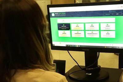 Mulher acessa o portal de serviços do departamento estadual de trânsito.