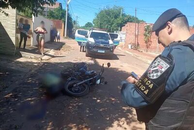 Corpo de Ademir ao lado de motocicleta na rua onde foi executado.