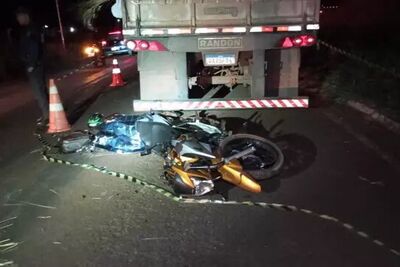 Corpo da vítima caído na via, ao lado da moto em que pilotava e de caminhão bitrem.