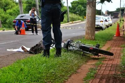 Bicicleta elétrica caída na calçada e vítima na avenida.