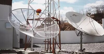 Antena parabólica instalada na área externa de uma empresa. 