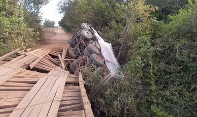 Caminhão ficou pendurado em ponte de madeira que cedeu. 