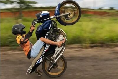 Homem empinando moto, prática conhecida como 