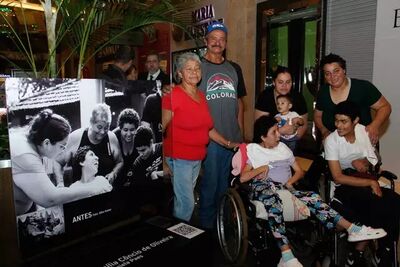 Dona Maria e a família ao lado de imagem ecolhida para exposição. Foto: Juliano Almeida