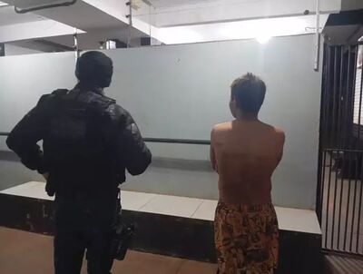 Adolescente ao lado de policial militar no pátio da Depac, em Dourados. Foto: Leandro Holsbach