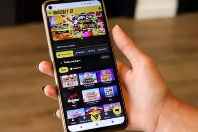 Mulher segura celular com aplicativo de jogos. Foto: Arquivo/Henrique Kawaminami