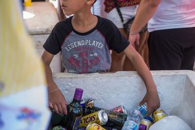 Criança ajuda na venda de bedida alcóolica no carnaval de rua de SP