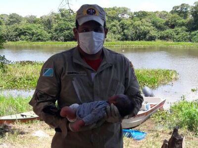 Bombeiro segura o menino após fazer o socorro no Pantanal de MS