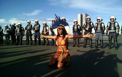 Índia faz pose em frente ao cordão de isolamento de policiais militares, durante marcha rumo ao Congresso, em Brasília