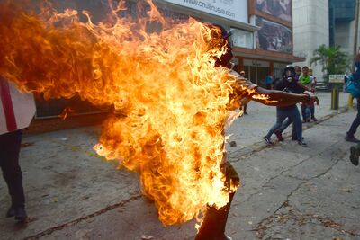 Corpo de manifestante pega fogo após explosão de tanque de gás durante protesto em Caracas