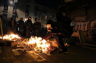 Policiais em frente a manifestante em protestos na noite da eleição presidencial em Menilmontant, distrito de Paris