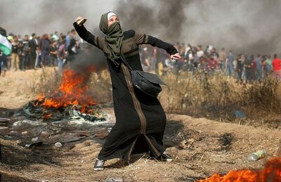 Palestina lança pedra durante protesto na Faixa de Gaza, nesta sexta-feira (13)