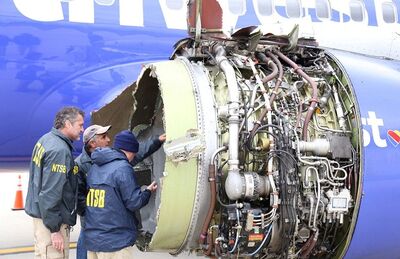 Investigadores examinam danos no motor do avião da Southwest Airlines que fez um pouso forçado na Filadélfia na terça-feira (17), após explosão