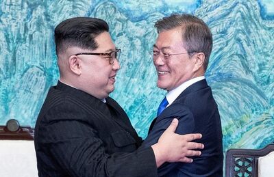 O presidente sul-coreano Moon Jae-in e o líder da Coreia do Norte Kim Jong-un se abraçam durante encontro na zona desmilitarizada que separa os dois países