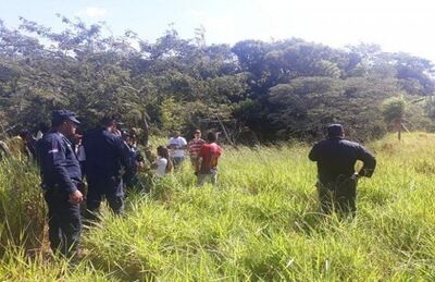 Policiais e parentes do rapaz onde corpo foi encontrado, na zona rural de Pedro Juan