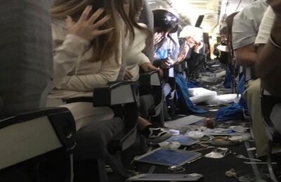 Passageiros observam objetos espalhados no chão de avião da Aerolineas Argentinas após forte turbulência em voo entre Miami e Buenos Aires, na quinta-feira (18)