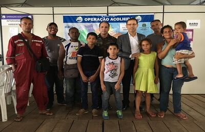 Bilionário Carlos Wizard (de paletó) acolhe venezuelanos recém-chegados ao Brasil