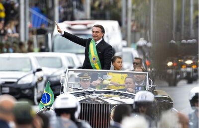 Ivo Cezar Gonzaga, de 9 anos, desfila ao lado de Jair Bolsonaro no Rolls-Royce presidencial