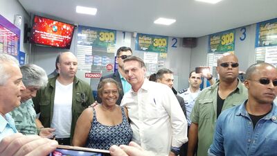 Presidente Jair Bolsonaro tira foto com simpatizante após fazer aposta em lotérica de Brasília