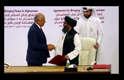 Abdul Ghani Baradar, líder da delegação do Talibã, e Zalmay Khalilzad, enviado dos EUA para a paz no Afeganistão, se cumprimentam depois de assinar acordo em Doha, no Catar, neste sábado (29)