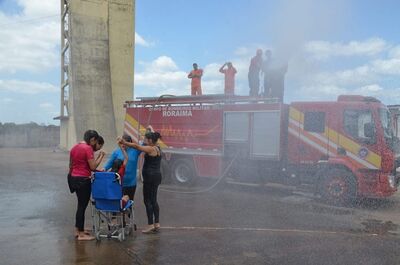 Janaína realizando o desejo de tomar o banho com água do caminhão de bombeiros