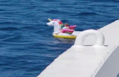 Uma criança flutua em um unicórnio inflável na costa de Antirrio, na Grécia, antes de ser resgatada por tripulantes de um navio