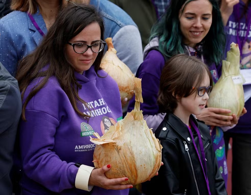 Mulher segura uma cebola gigante na competição russa de vegetais grandes em Moscou. Foto: REUTERS/Yulia Morozova

